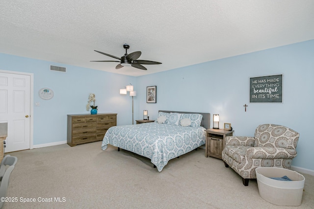 carpeted bedroom with a ceiling fan, visible vents, a textured ceiling, and baseboards