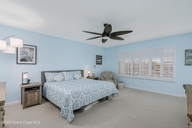 bedroom featuring light carpet, ceiling fan, a textured ceiling, and baseboards