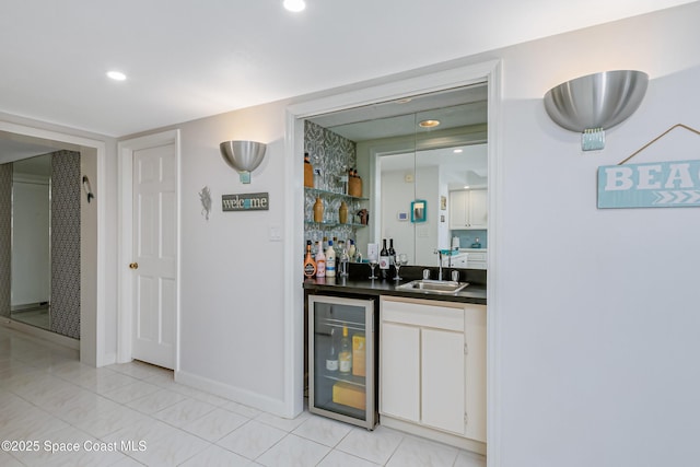 bar with recessed lighting, a sink, wet bar, beverage cooler, and baseboards