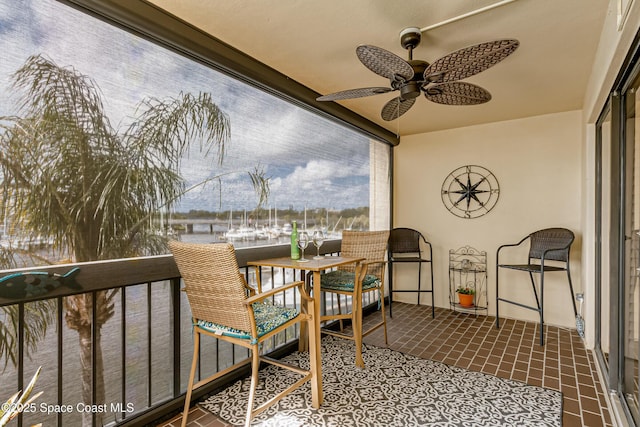 balcony featuring a water view and ceiling fan