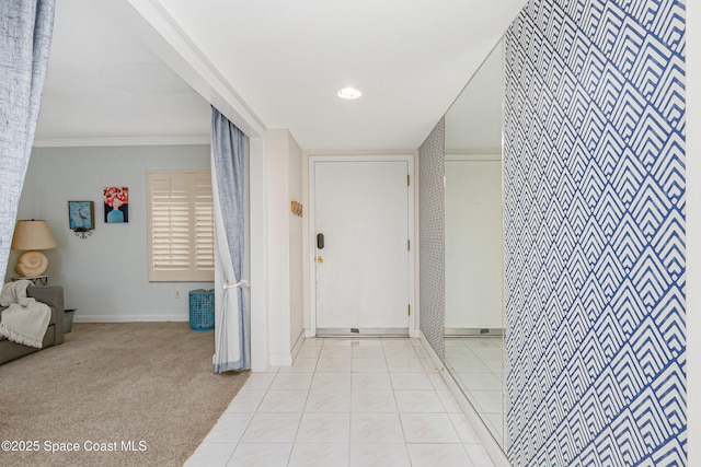 hall with ornamental molding, carpet, baseboards, and tile patterned floors