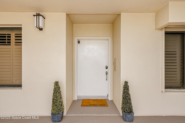 doorway to property featuring stucco siding