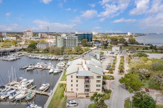 birds eye view of property with a water view and a city view