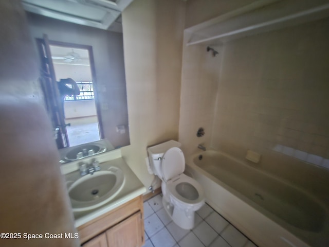 full bathroom with tile patterned flooring, tiled shower / bath, vanity, and toilet