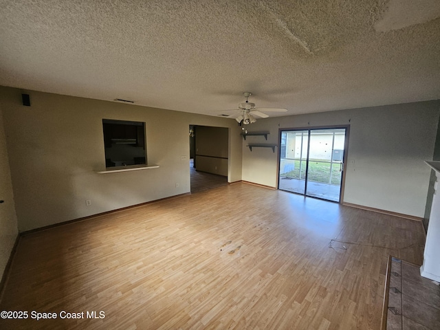 spare room with hardwood / wood-style flooring, ceiling fan, and a textured ceiling