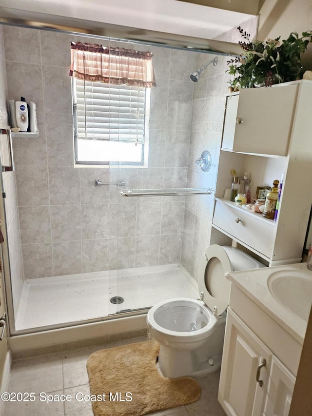 bathroom with tile patterned flooring, vanity, an enclosed shower, and toilet