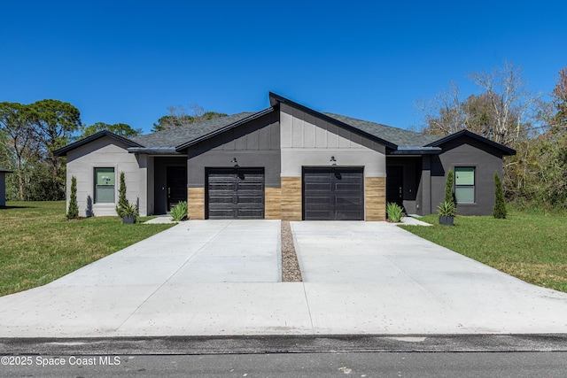 view of front of house featuring driveway, board and batten siding, an attached garage, and a front yard