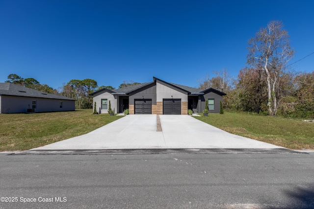 contemporary home with concrete driveway, a front lawn, an attached garage, and brick siding