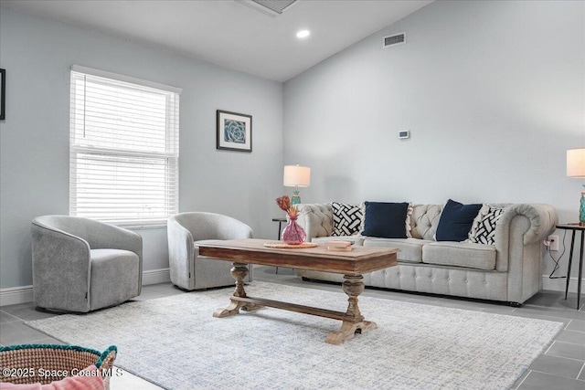 tiled living room featuring vaulted ceiling