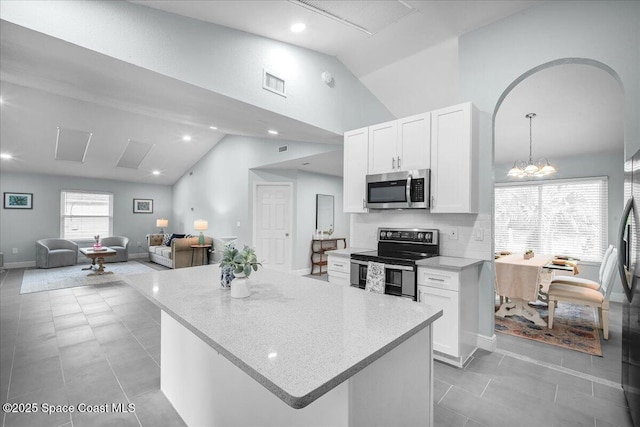 kitchen with white cabinetry, hanging light fixtures, stainless steel appliances, and a center island