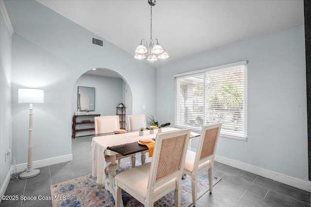 dining area featuring vaulted ceiling, tile patterned floors, and a chandelier