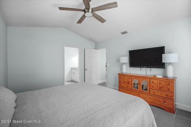 tiled bedroom featuring ceiling fan, lofted ceiling, and connected bathroom