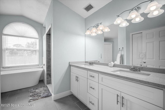 bathroom with vanity, lofted ceiling, tile patterned floors, and a tub to relax in