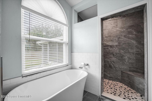 bathroom featuring tile patterned flooring, shower with separate bathtub, plenty of natural light, and tile walls