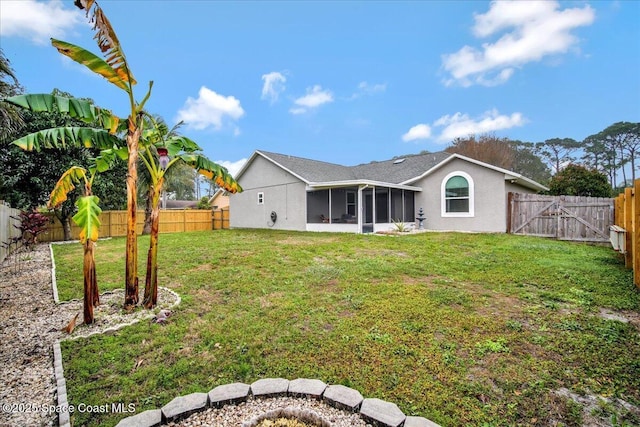 back of property with a lawn and a sunroom