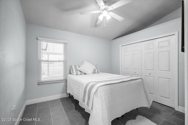 tiled bedroom featuring ceiling fan, vaulted ceiling, and a closet