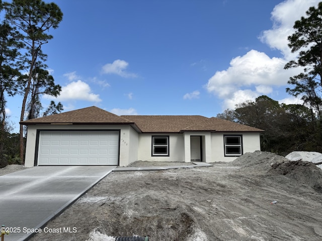 ranch-style house with a garage, driveway, roof with shingles, and stucco siding