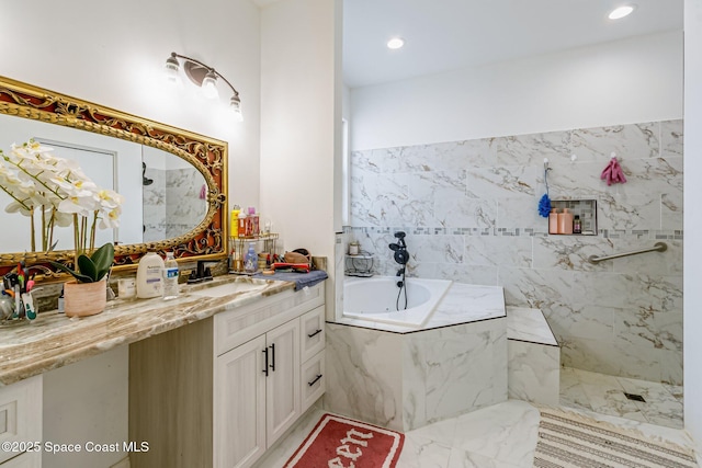 bathroom featuring vanity and tiled bath