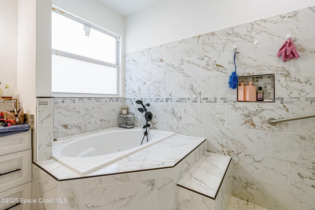 bathroom featuring vanity and tiled bath