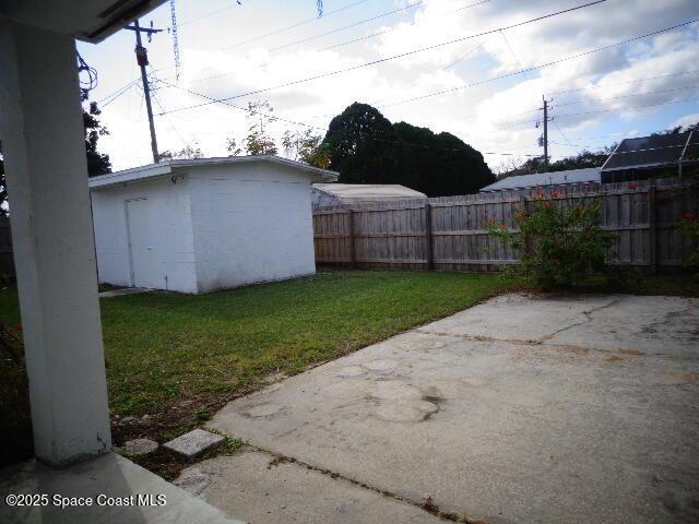 view of yard featuring a patio and a storage shed