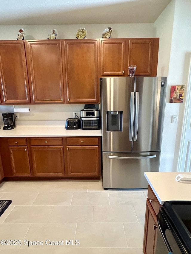 kitchen with stainless steel fridge with ice dispenser and light tile patterned floors