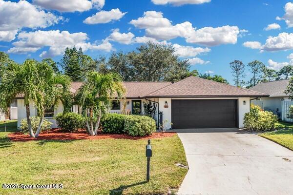 ranch-style home with a garage and a front yard