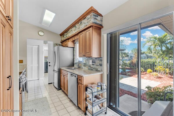 kitchen featuring sink, light tile patterned floors, backsplash, stainless steel appliances, and vaulted ceiling