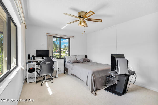 bedroom with ceiling fan and light carpet