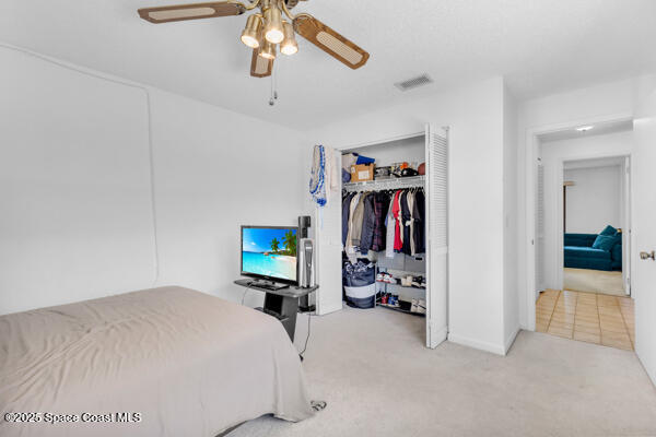 bedroom with carpet flooring, ceiling fan, and a closet