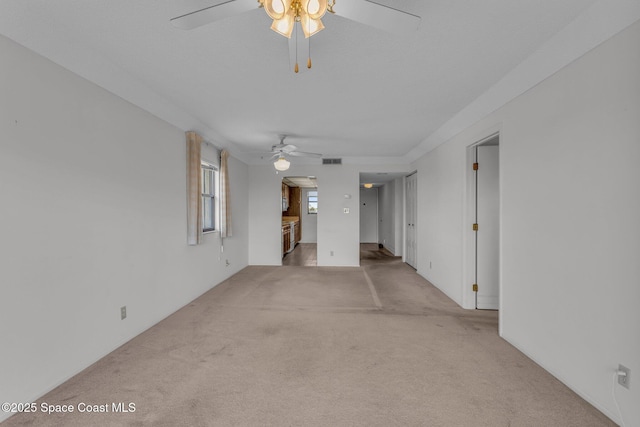 carpeted spare room with ceiling fan