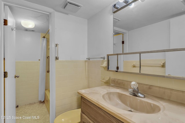 bathroom featuring vanity, tile walls, and shower / bath combo with shower curtain