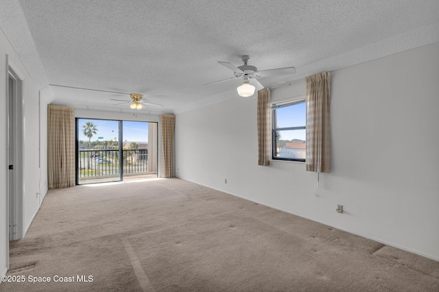 spare room with light carpet, ceiling fan, and a textured ceiling