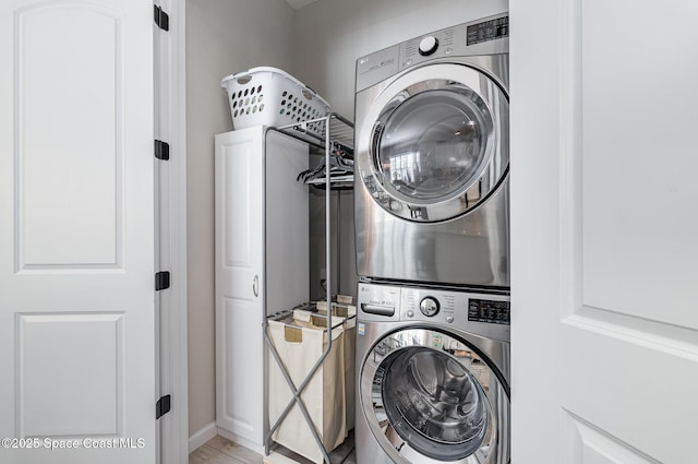 washroom featuring stacked washer and clothes dryer