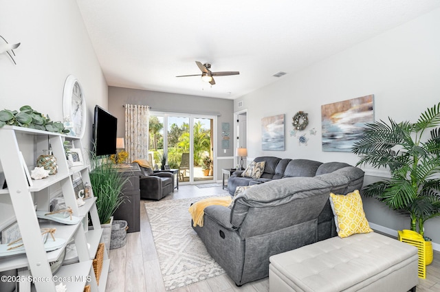 living room with light hardwood / wood-style flooring and ceiling fan