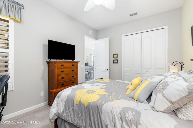 bedroom featuring ceiling fan, light hardwood / wood-style floors, and a closet