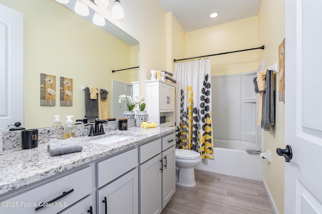 full bathroom featuring hardwood / wood-style floors, toilet, vanity, and shower / bath combination with curtain