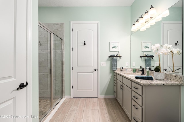 bathroom with vanity, an enclosed shower, and wood-type flooring