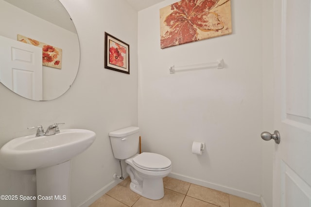 bathroom featuring sink, toilet, and tile patterned flooring