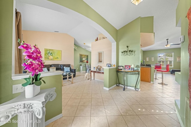 kitchen with light tile patterned floors, vaulted ceiling, kitchen peninsula, and ceiling fan