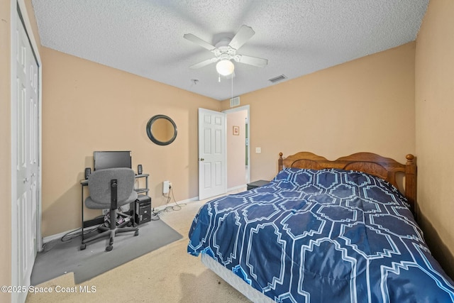 carpeted bedroom with ceiling fan and a textured ceiling