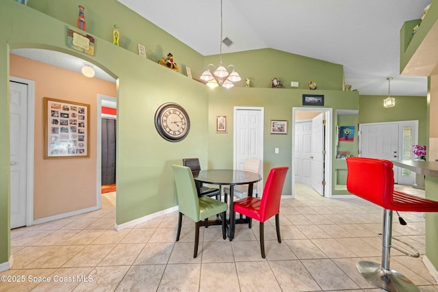 tiled dining room featuring lofted ceiling and a notable chandelier