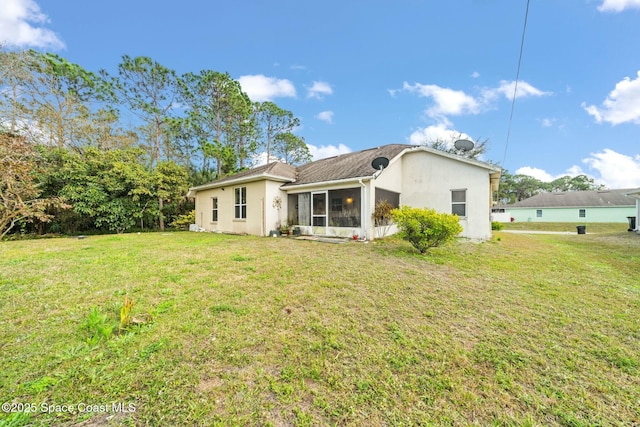 back of property with a lawn and a sunroom