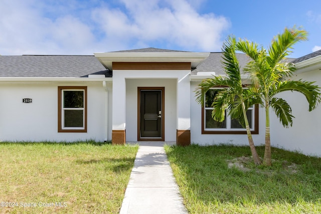 entrance to property with a lawn