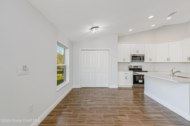 kitchen featuring white cabinetry, sink, vaulted ceiling, and appliances with stainless steel finishes