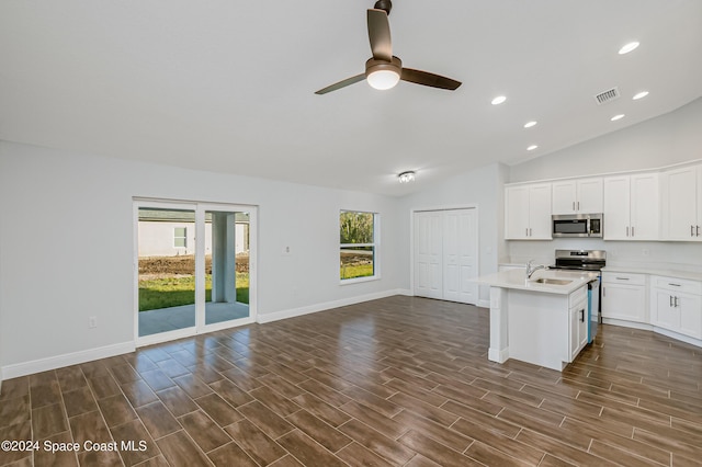 kitchen featuring white cabinetry, vaulted ceiling, appliances with stainless steel finishes, dark hardwood / wood-style floors, and an island with sink