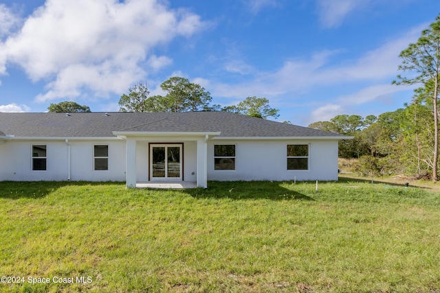 rear view of property featuring a lawn