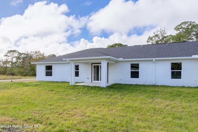 back of property featuring a lawn