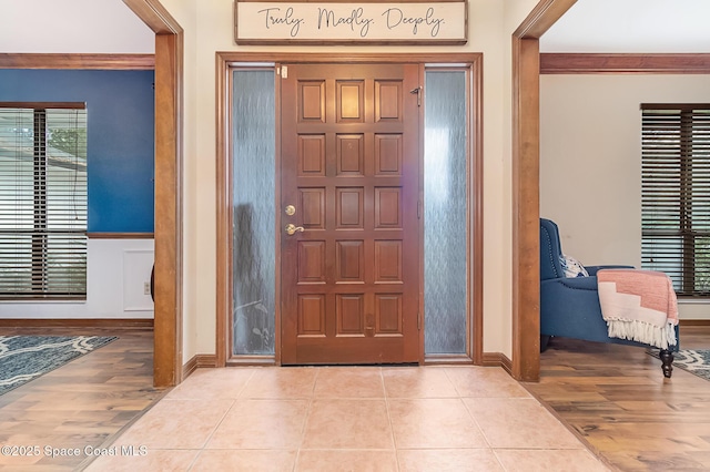 entryway featuring crown molding and light tile patterned floors