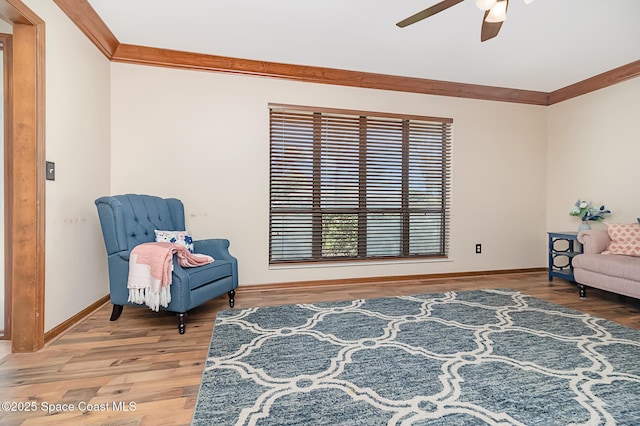 living area with hardwood / wood-style flooring, ornamental molding, and ceiling fan