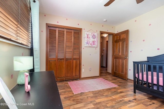 bedroom with dark wood-type flooring, ceiling fan, and a closet